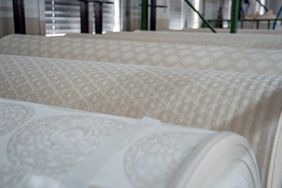 Mit den Jacquard-Webmaschinen werden grossflächige Muster in den Damast gewoben. Bilder aus der Produktion der Weberei Russikon.
